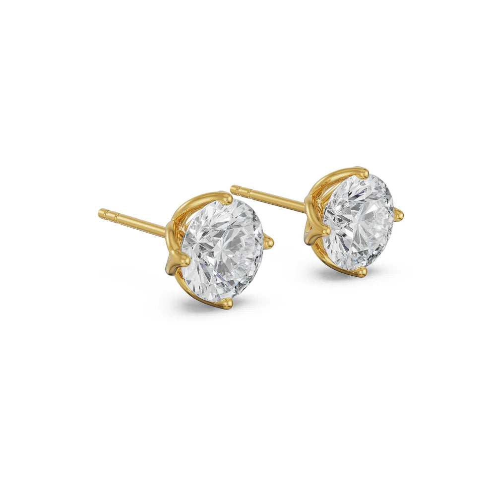 Gold earrings with clear gemstones on a white background