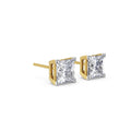 Pair of diamond stud earrings with gold prongs on a white background
